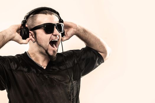 creative rapper in the headphones and dark glasses performs a rap song .photo on a white background and has an empty space for your text