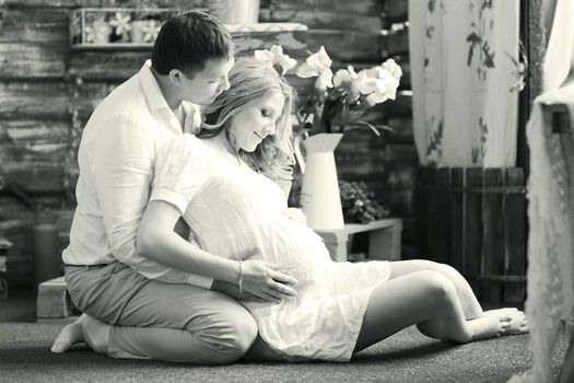 Portrait of a happy couple - husband and pregnant wife, black-and-white photo