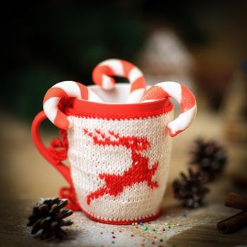 blurred image of Christmas mug and cinnamon sticks on wooden background.photo with copy space