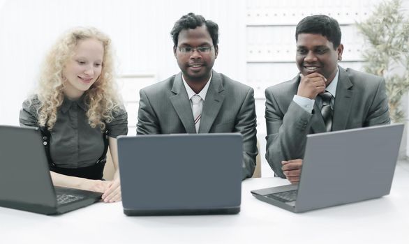three employees sitting on the workplace in the office