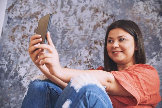 Plus size model making selfie via her smartphone