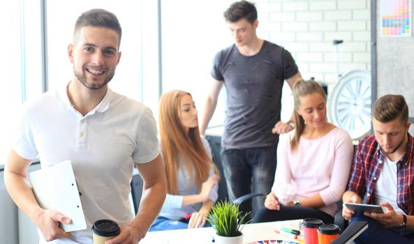 Businessman with colleagues in the background in office