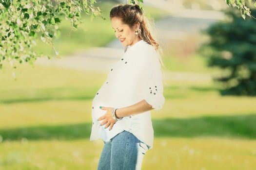 beautiful pregnant woman on a walk in the Park on a summer day