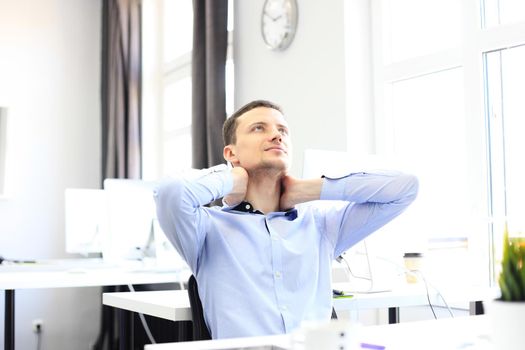 Portrait of a delighted businessman relaxing in his office