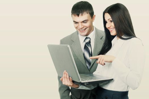 meeting business partners with a laptop on a white background. Girl shows a finger on the screen and smiling