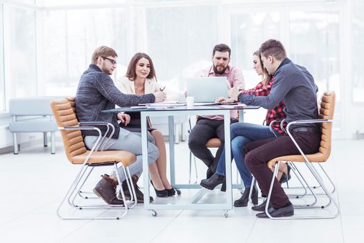 successful business team discussing work documents sitting behind a Desk in the office