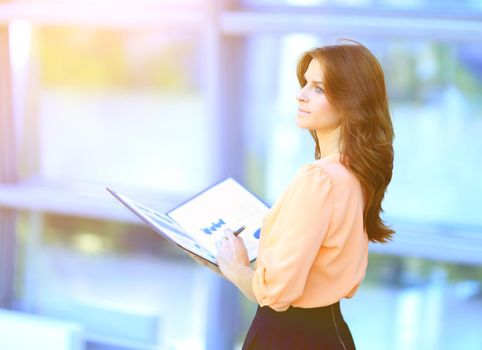 successful business woman with financial documents on blurred background