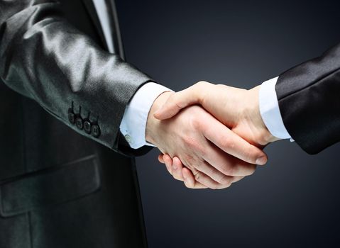 close up.handshake of business partners on dark background.concept of partnership
