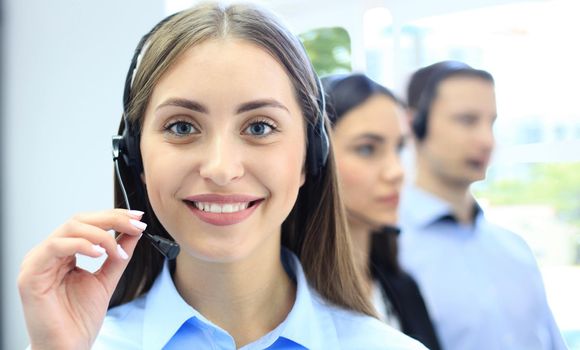 Businesswoman wearing microphone headset using computer in the office - operator, call center.