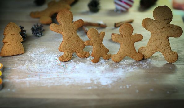 candles and gingerbread men at the Christmas table .photo with copy space.