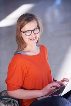 happy student girl working on laptop computer at modern school university indoors