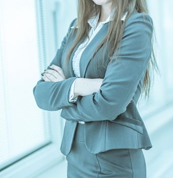 closeup of successful business woman standing near window with hands clasped in front of him .photo on a light background