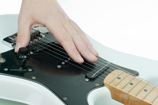 closeup.the hand of the musician stroking the strings of a guitar.isolated on a white background