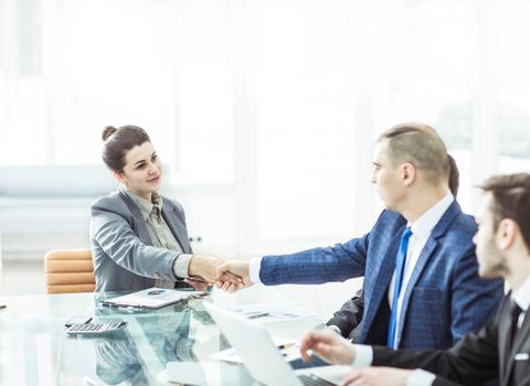 handshake of a Manager and a customer at the Desk in the office.the photo has a empty space for your text