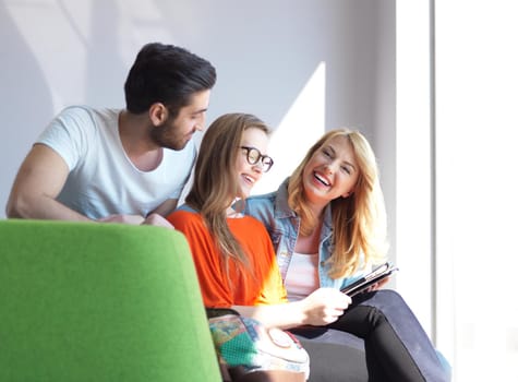 students group working on school  project  together on tablet computer  at modern university