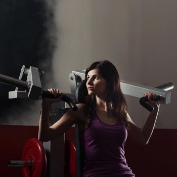 Young modern business woman at a fitness lesson in a modern fitness club.photo on a dark background