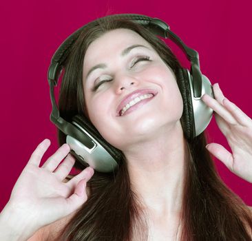 cheerful young woman listening to music through headphones .photo with copy space