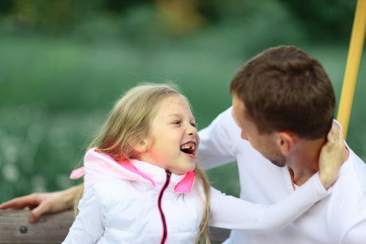 dad and daughter playing in the Park on a Sunny day.the photo has a empty space for your text