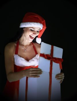 surprised young woman in costume of Santa Claus opening a Christmas gift.photo with copy space.