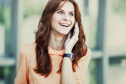 business woman talking on smartphone on background office.the photo has a empty space for your text