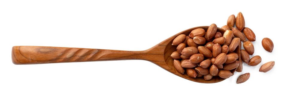 Spoon full with peanuts isolated on white background