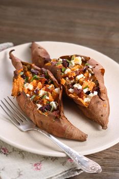 Baked sweet potato stuffed with chopped sun-dried tomatoes, olives, feta cheese and basil with aromatic dressing