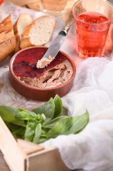 Delicate chicken pate with pureed cranberries, drenched in jelly. Served with pieces of baguette and fruit drink, in a wooden box. Country style food. 