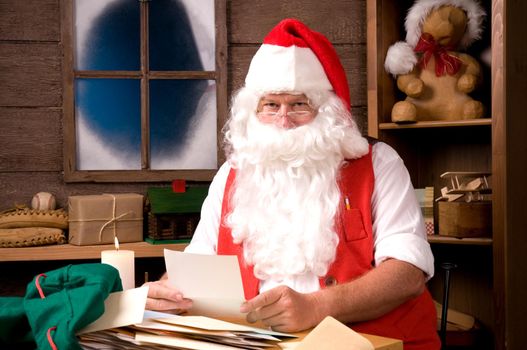 Santa Claus Sitting in His Workshop reading a letter. Horizontal  Composition.