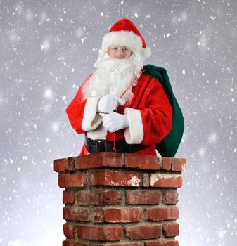 Santa Claus inside a brick chimney with his bag of toys flung over his shoulder. Vertical format with a snowy background.