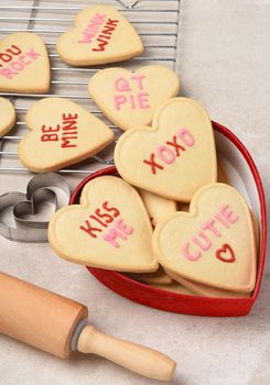 Valentines Day Concept: Heart shaped sugar cookies in a heart shaped box with cooling rack and rolling pin. 