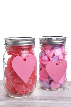 Two canning jars filled with Valentines Day candy hearts. Vertical format with copy space.