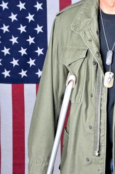 Close up of American veteran with crutch and flag in background