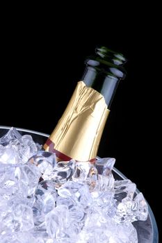 Open Champagne Bottle in Crystal Ice Bucket isolated over black