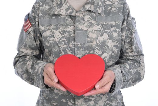 Closeup of a soldier holding a red Heart Shaped Valentines Day candy box.