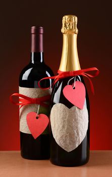 Champagne and wine bottles decorated for Valentines Day. The bottles have red ribbons and heart shaped tags. Vertical format on a light to dark red background.