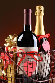 Closeup of a wire shopping basket with Valentines Presents. Vertical Format on a light to dark red background. Items include champagne, wine, gift boxes. The bottles have red ribbons and heart shaped gift tags.