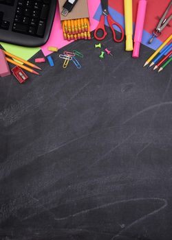 School Supplies: Still life on erased Chalkboard of assorted school supplies with copy space.