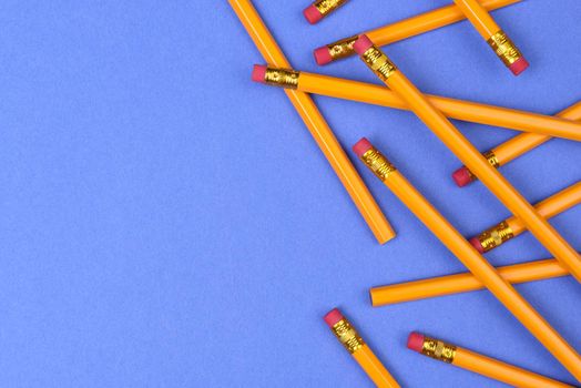 Back to School theme: Top view of a group of pencils on a blue background with copy space.