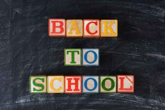 Childrens blocks spelling out Back To School on a chalk board. Horizontal format.