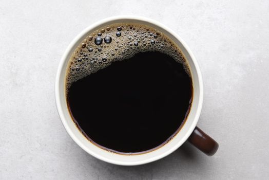 Black coffee in Brown Mug on light gray tile