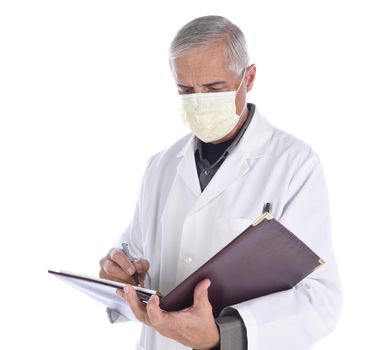 Portrait of a middle aged doctor wearing a surgical mask and lab coat looking down as he writes in a notebook. Isolated on white.