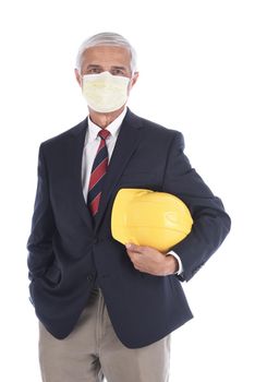 A builder or architect holding a yellow hard hat under his arm while wearing a protective mask, Isolated on white.