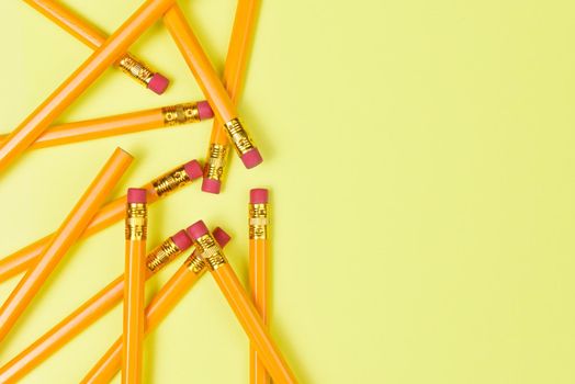Back to School theme: Top view of a group of pencils on a yellow background with copy space.