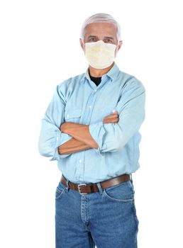 Middle aged man wearing a covid-19 protective mask, blue Jeans and work shirt with arms folded isolated on white