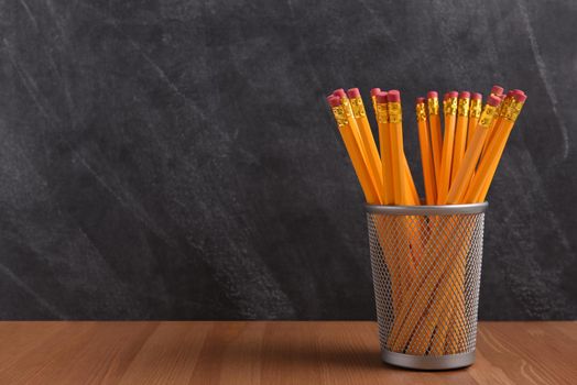 Back to School Concept: A pencil cup in front of a classroom blackboard.
