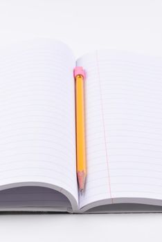 Theme Book and Pencil: closeup of an open notebook with a sharpened pencil in the fold, with shallow depth of field. 