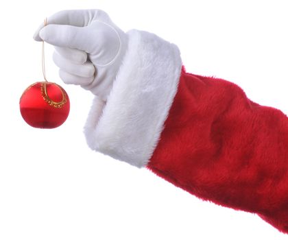 Santa Claus holding a Christmas ornament by a string in his fingers. Isolated over white only hand and arm are visible.