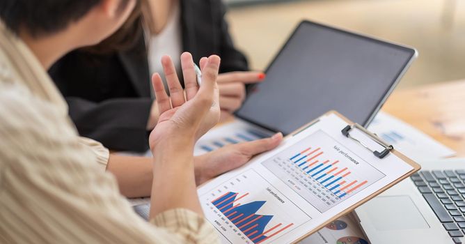 Business people using calculator and laptop computer for discussion about profit, tax, financial, Makerting.