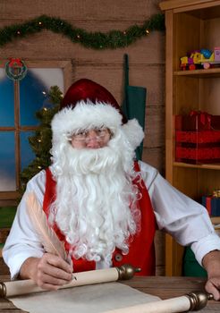 Santa Claus in his workshop writing his Naughty and Nice List.