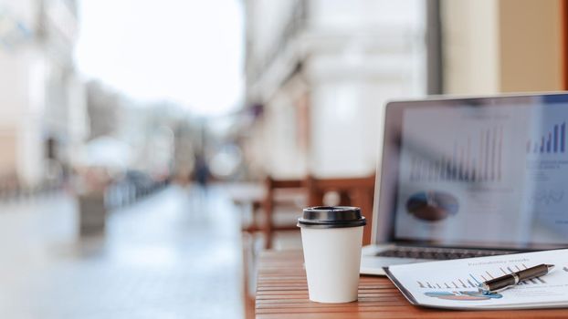 close up. background image of a table with a laptop on the cafe terrace. photo with a copy-space.